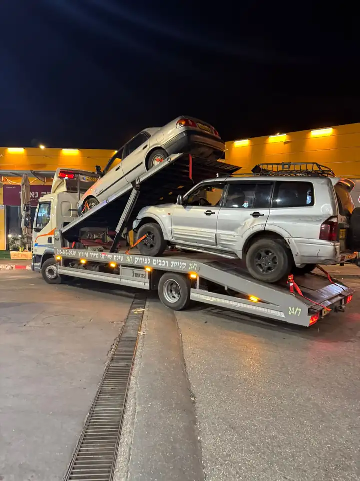 גרר של שילת מעמיס רכב שטח ורכב פרטי בלילה