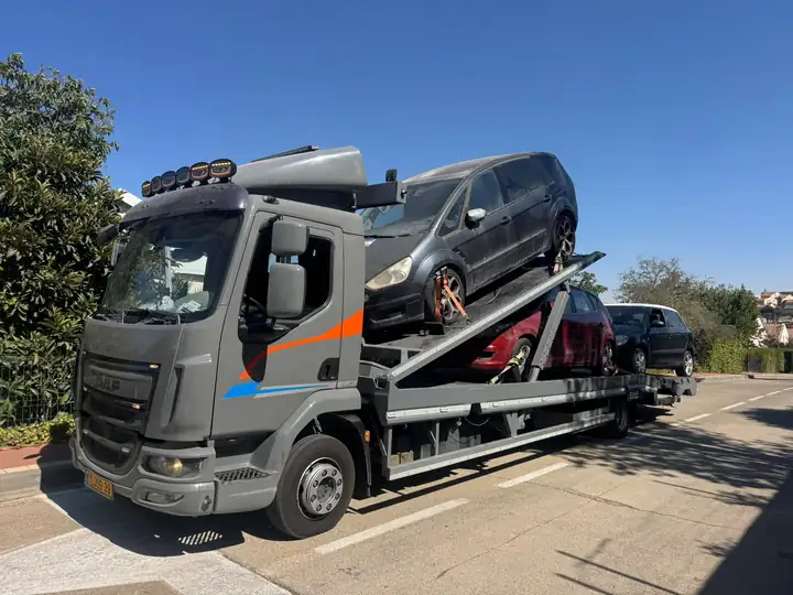 גרר DAF אפור של שילת עם שני רכבים על גרר דו־קומתי